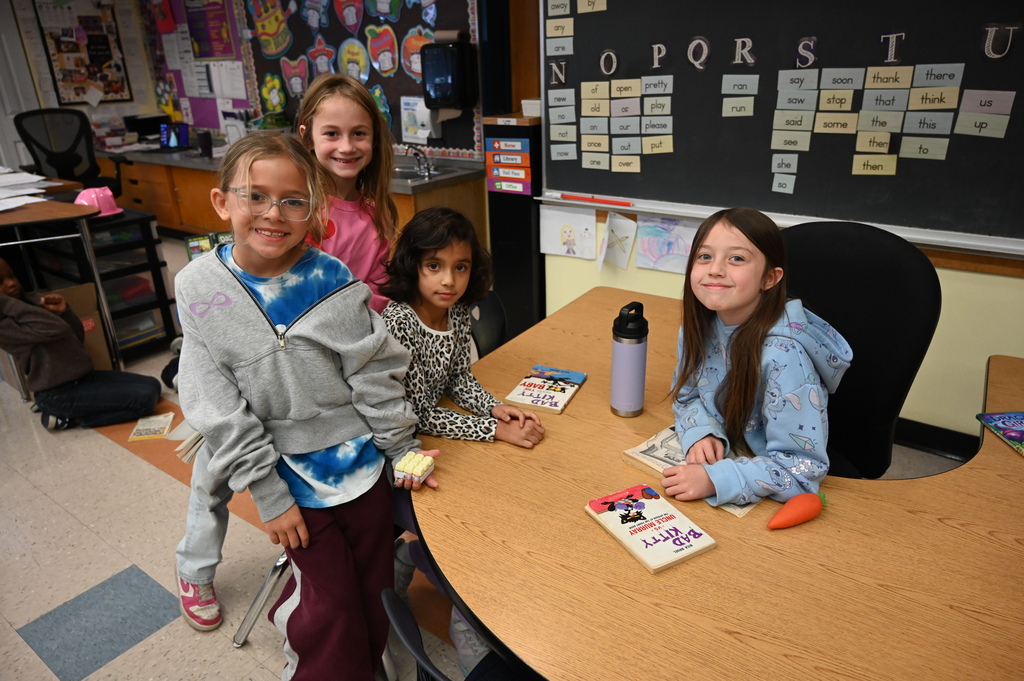 group of four students smiling at the camera