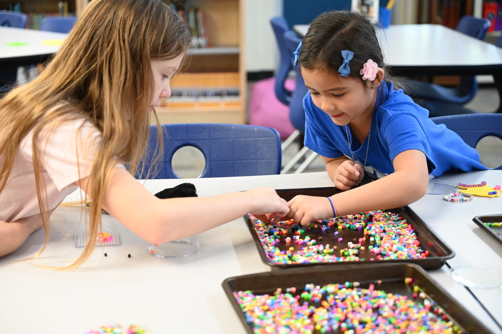 students making crafts together sorting through beads