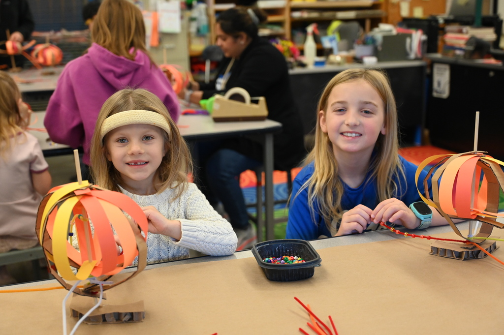 students smiling working on their sculptures 