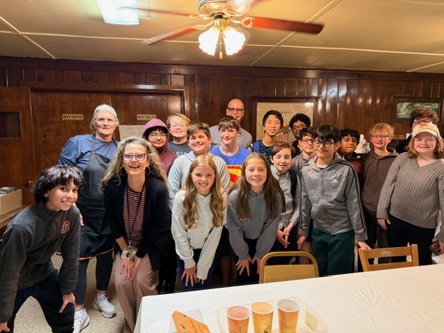 group of german club students standing in front of the camera smiling at the german american club