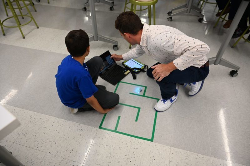 Coding & Robotics Teacher Mr. Ashline works with a student on a project.