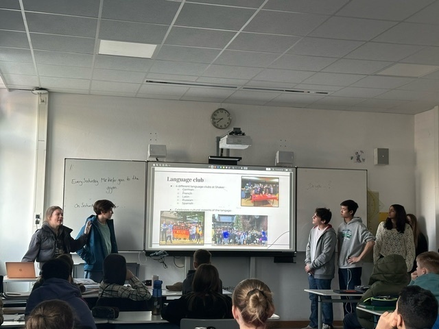 Students give a presentation at the front of a classroom in Germany.