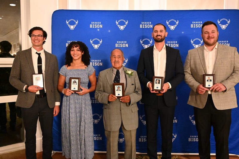 Five of the 10 members of the Shaker Athletic Hall of Fame Class of 2024 pose together.