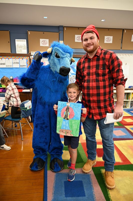 This student shows off his drawing of Paul and Babe with none other than Paul and Babe!