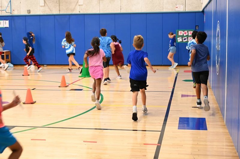 Running club doing a lap around the gym