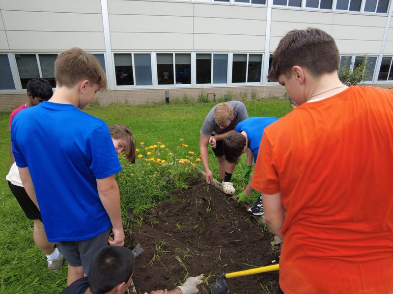 Students tend to a flower bed in the SHS garden.