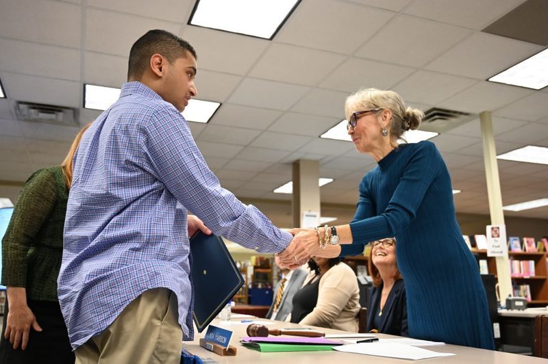 October Kids Care recipient Anthony Sadek receives his award from Board of Education President Linda Harrison.