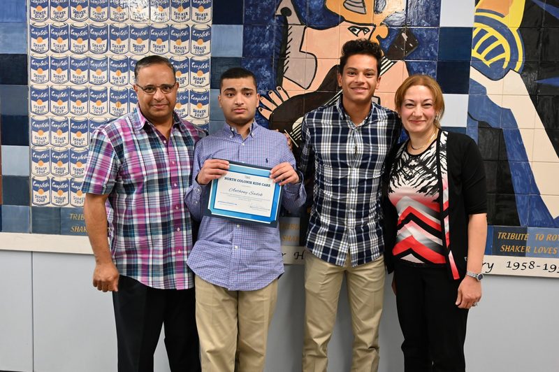 October Kids Care recipient Anthony Sadek shows off his award along with his proud family.
