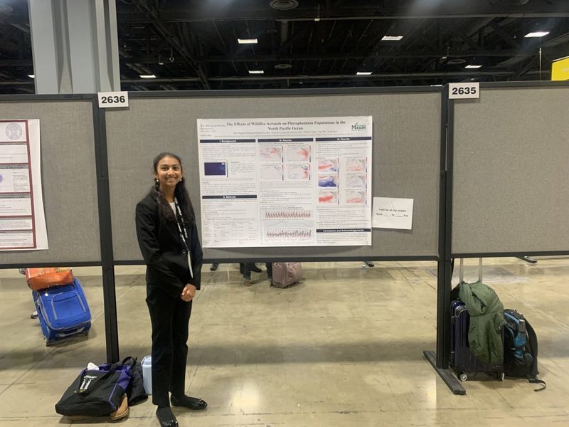 Ella Bagchi poses in front of her presentation at the AGU’s annual winter meeting.