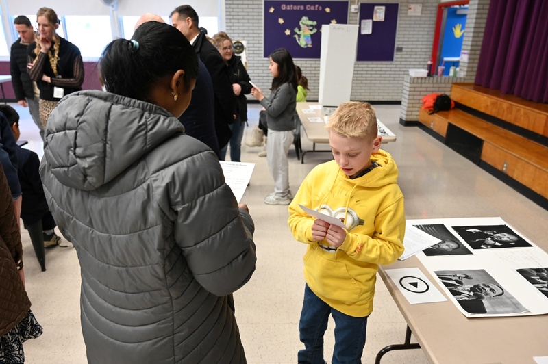 A student reads his presentation of Dr. Martin Luther King, Jr. to a visiting parent.