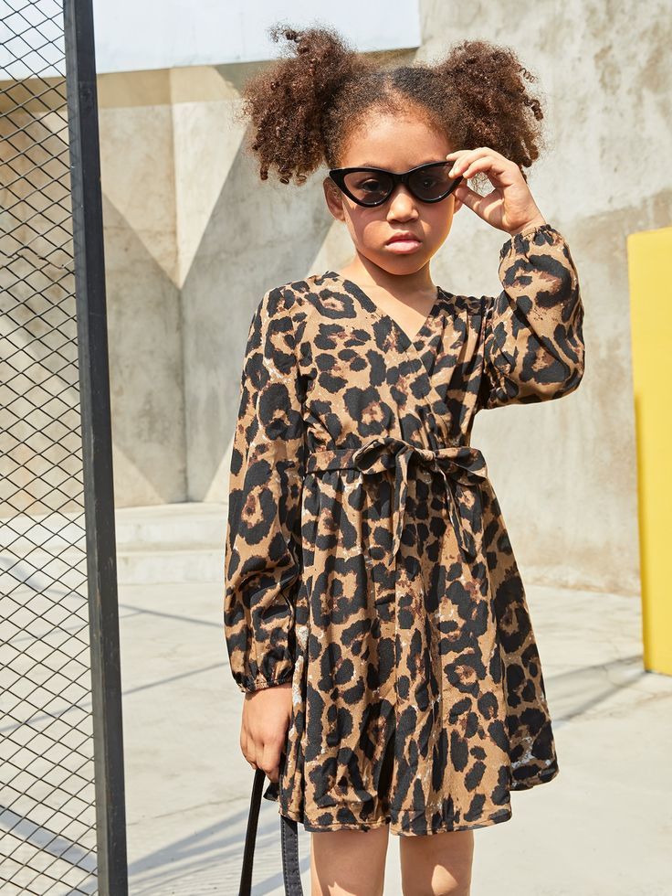 Young girl wearing glasses and a leopard print dress.