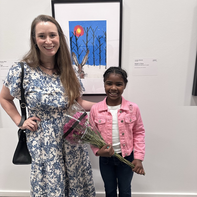 student and teacher posing in front artwork 