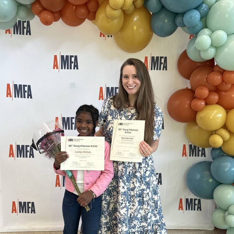 student and teacher posing in front of balloons