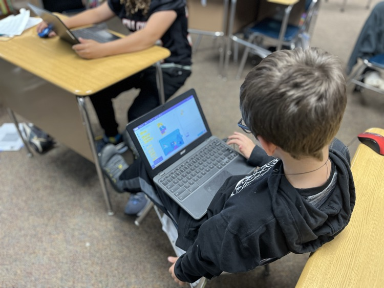 A student block coding in Scratch