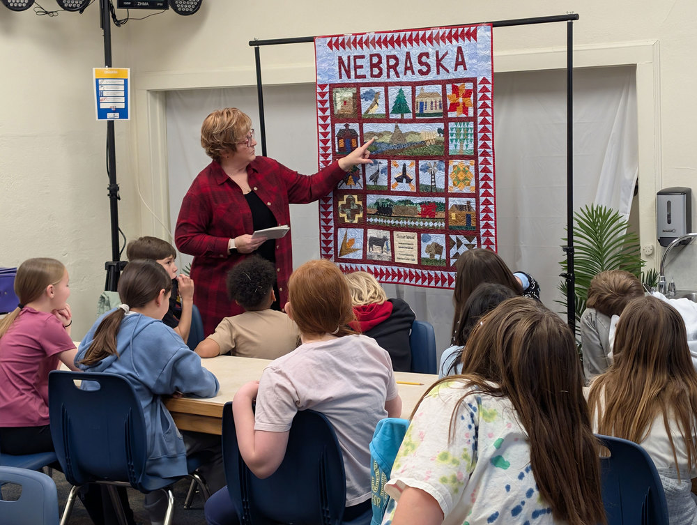 Students seeing a quilt that tells the history of Nebraska