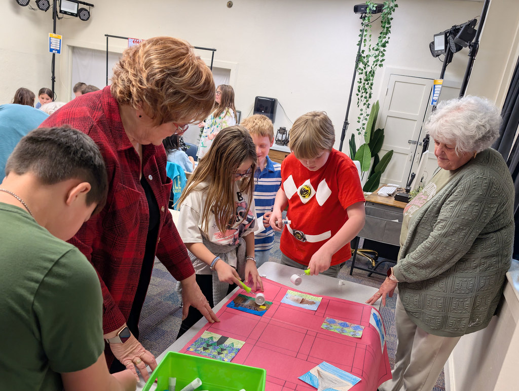 Students gluing together paper quilt patches.
