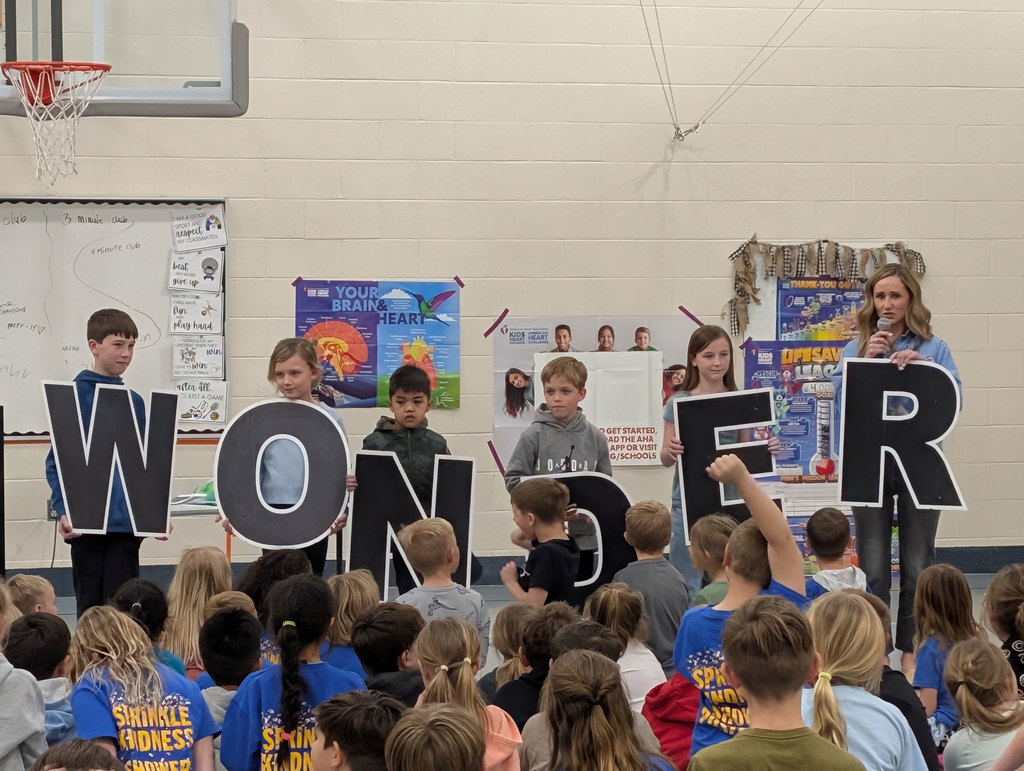Students and principal holding up letters that spell "WONDER".
