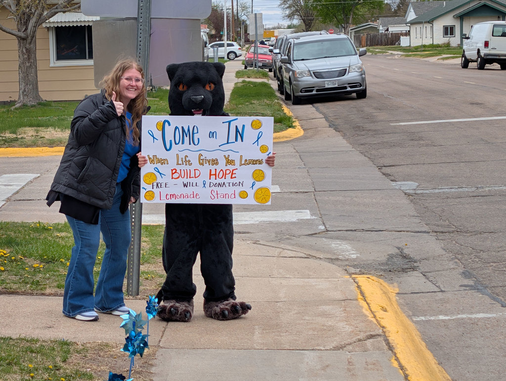 Mrs. Allen and the Cody Panther mascot welcoming families to school for their fundraiser.