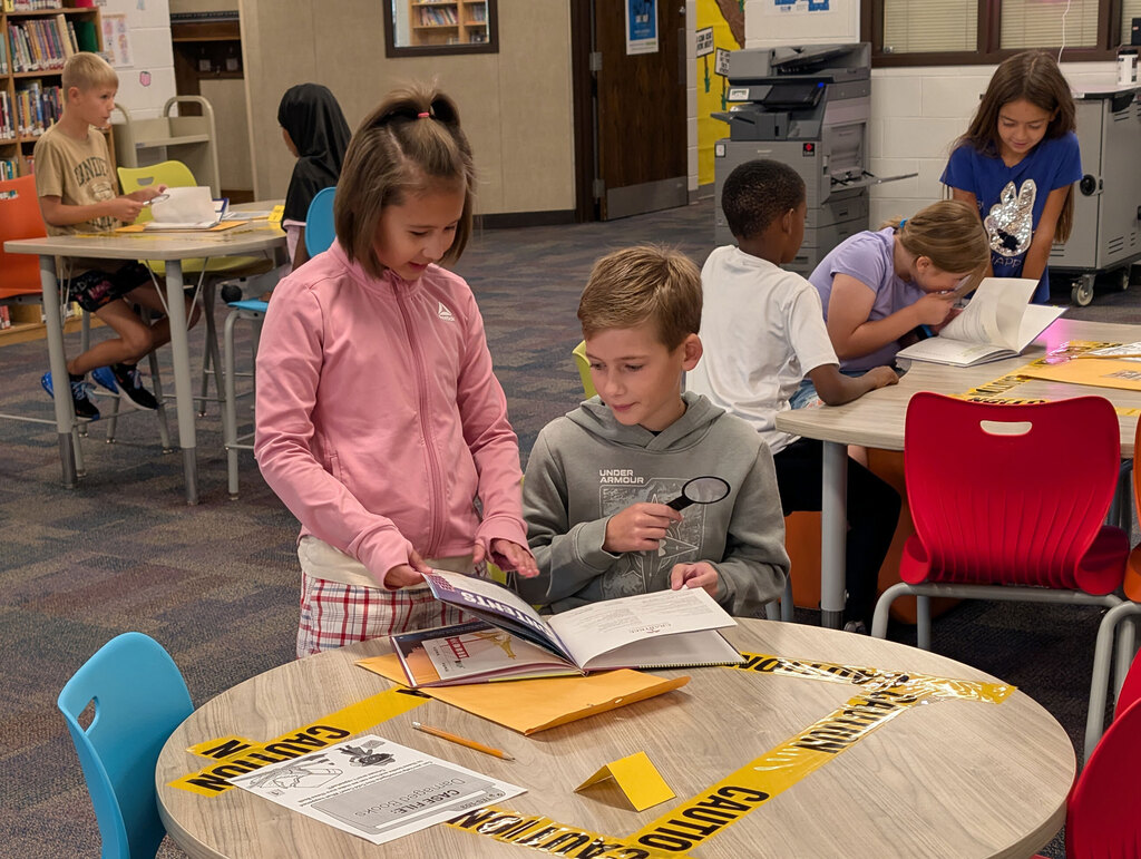 Students in groups investigating clues for class activity.