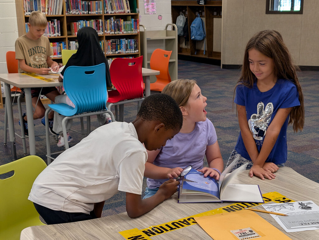 Students finding clues in book.