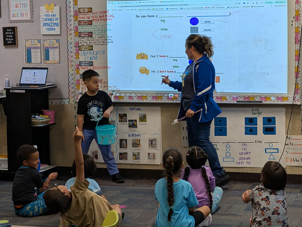 Student helping demonstrate activity with teacher for the class