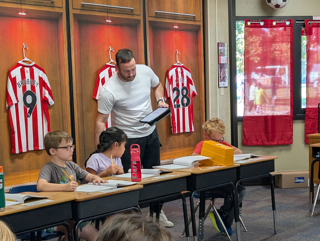 Students showing work with teacher.