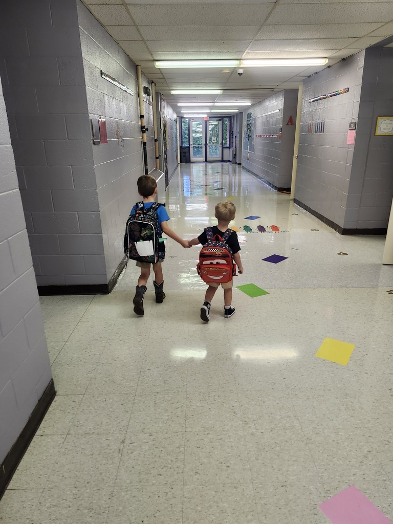 A big kindergartener is helping a Panther Cub to class.