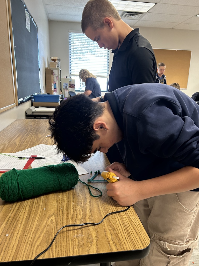Two boys hot glueing their art