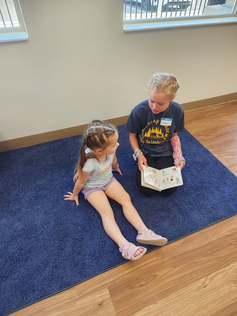 girls reading to a young girl