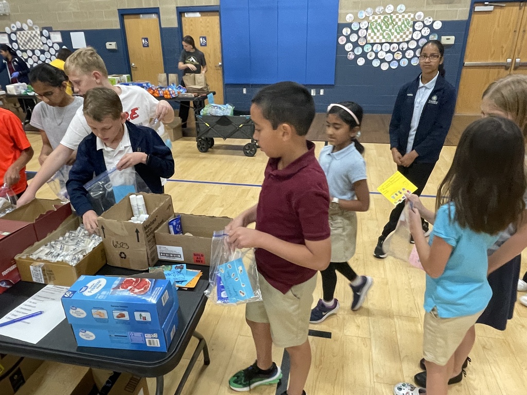six students waiting in line to gather items for hygiene kits
