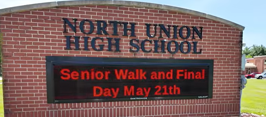 A brick sign reads "North Union High School". Below is a digital sign stating "Senior Walk and Final Day May 21st".