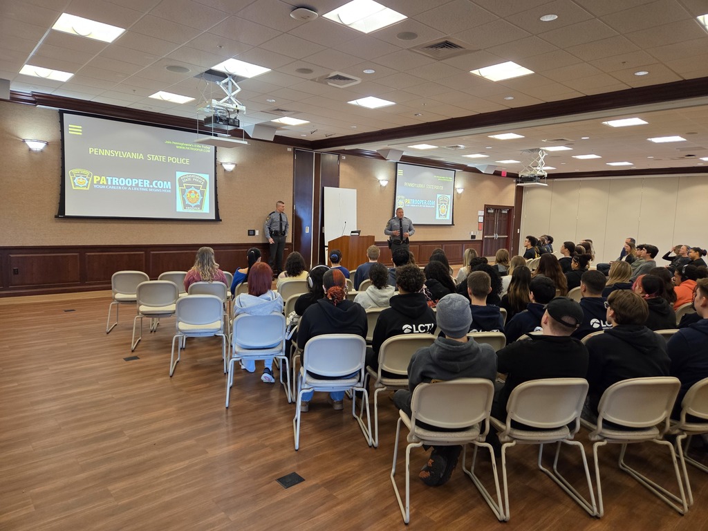 Picture of students with their backs to the camera listening to two police officers speak