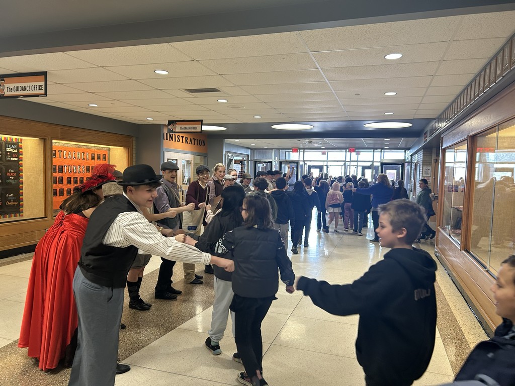 Newsies Cast fist bumping elementary students walking out of the door