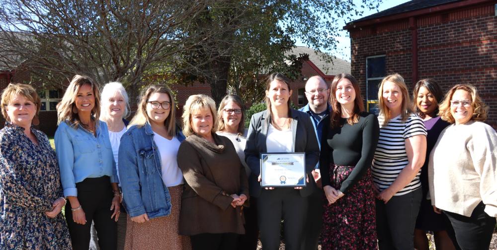 group of elementary teachers pose with award