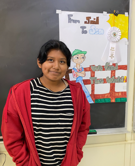 a young girl stands in front of her award-winning poster