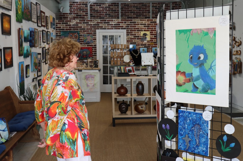 adult browsing student artwork in an art gallery
