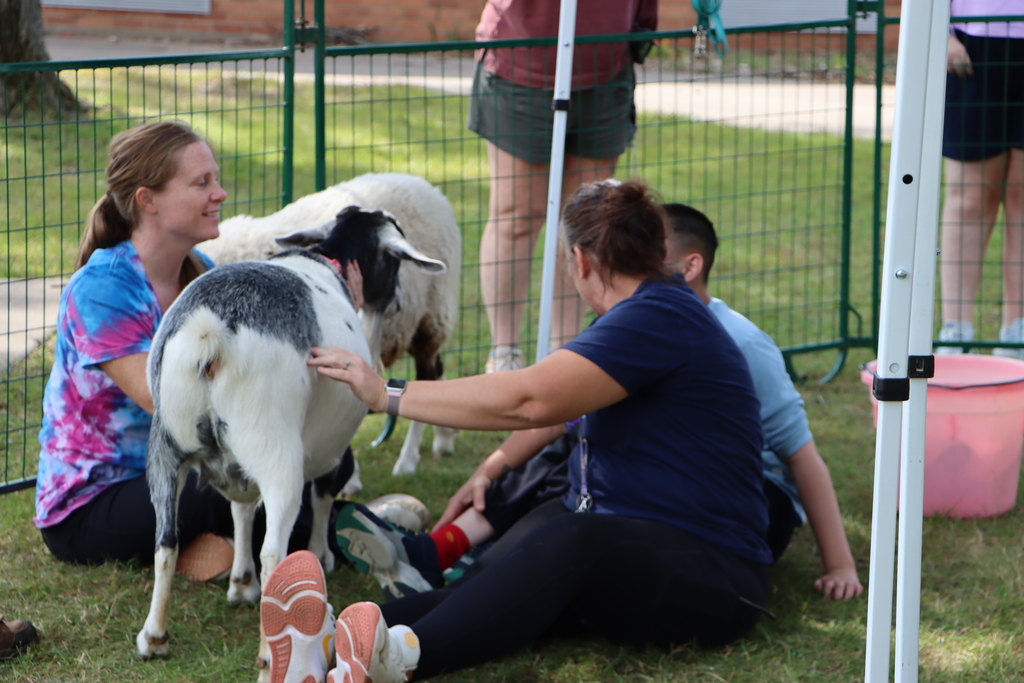 Staff and student petting goat