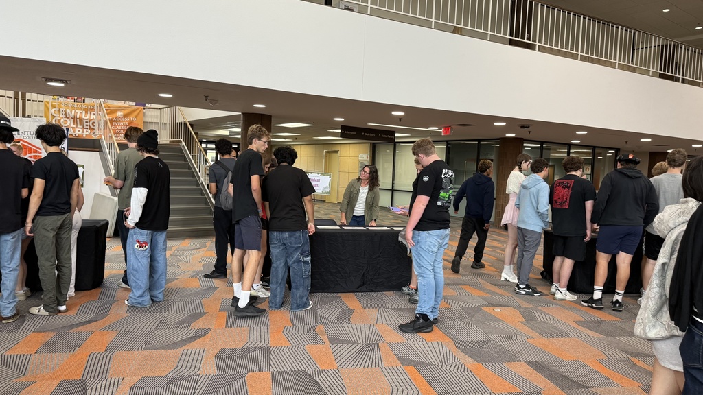 Students going around tables and talking with staff.