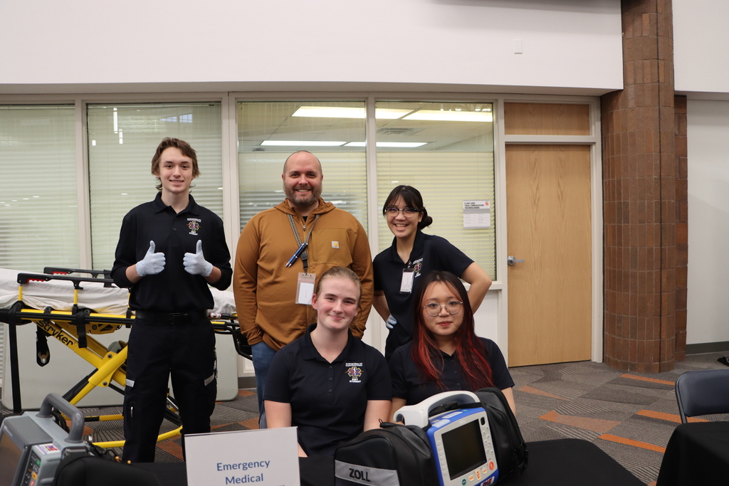 Staff and students at a booth smiling.