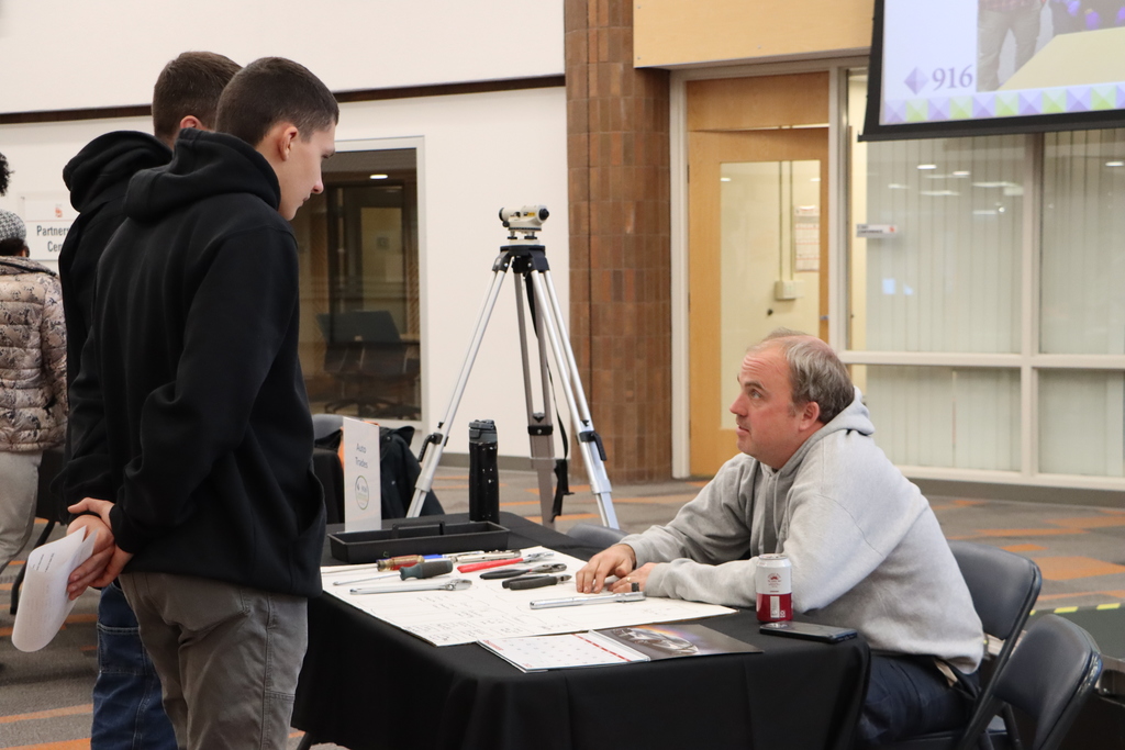 Staff talking with guests at booth.