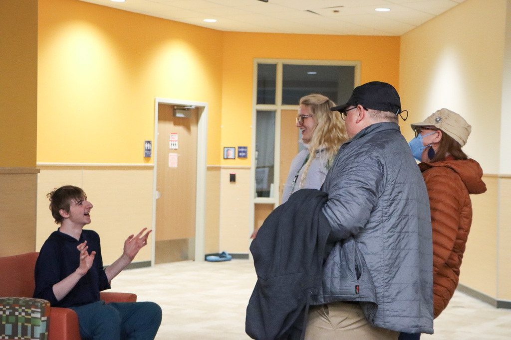 Image of student, staff, and family talking with each other.