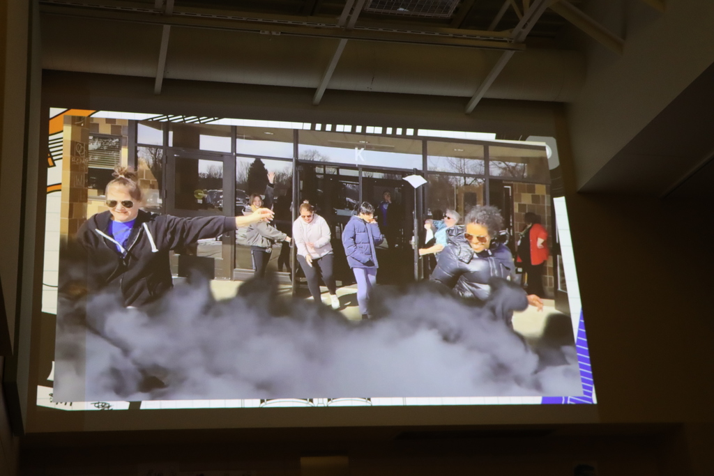 Image of a video of students and staff coming out of a building.