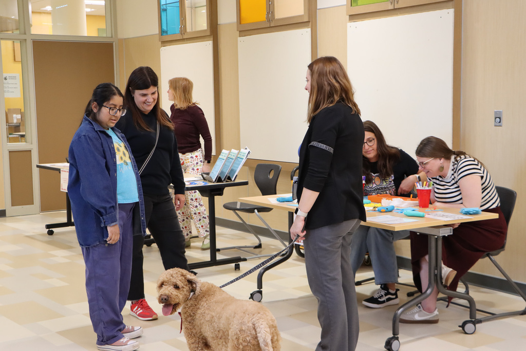 Image of staff, student, and parent talking to each other in a hallway. 