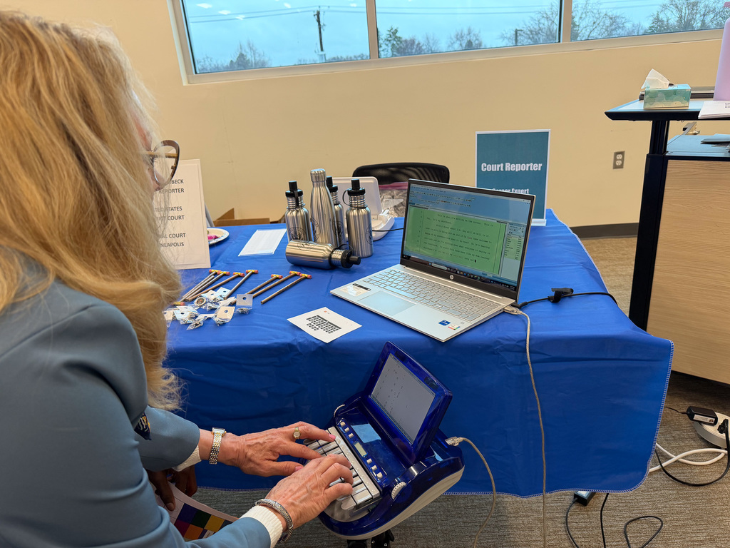 A career professional showing a student how to use a stenograph.