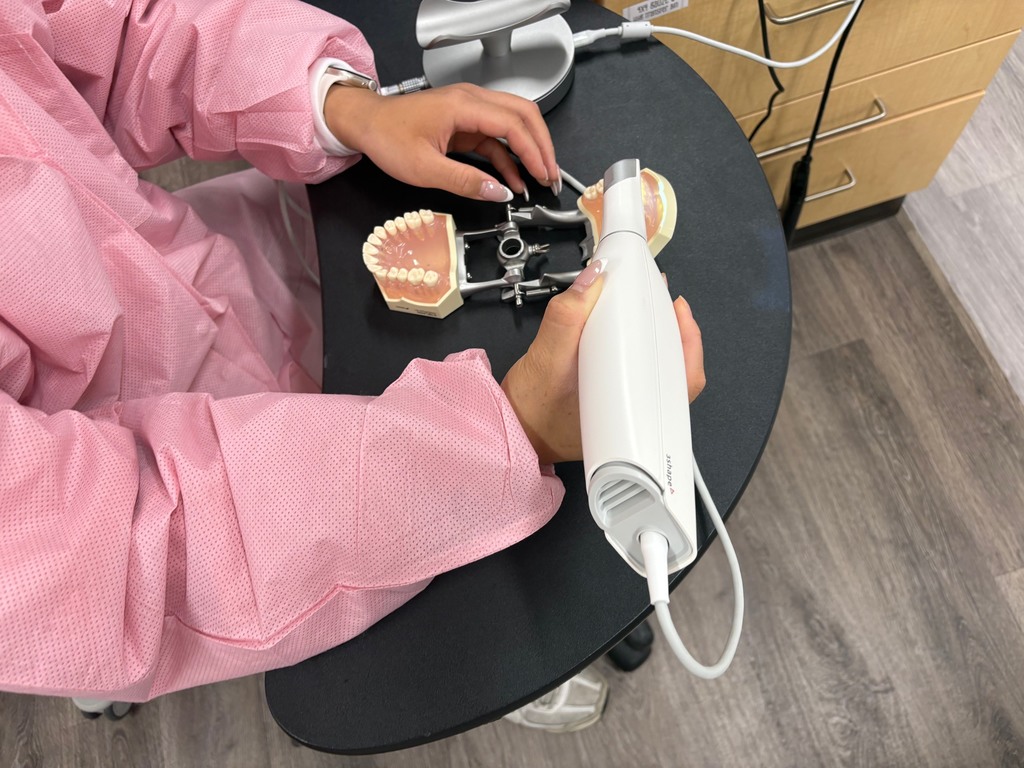 Student using a 3Shape TRIOS scanner on fake teeth model.