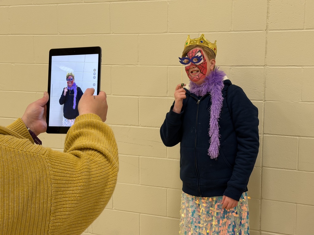 Image of staff taking a picture of a student on an iPad. 