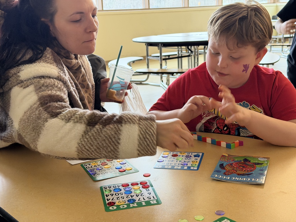 Parent and student playing bingo in the lunchroom. 