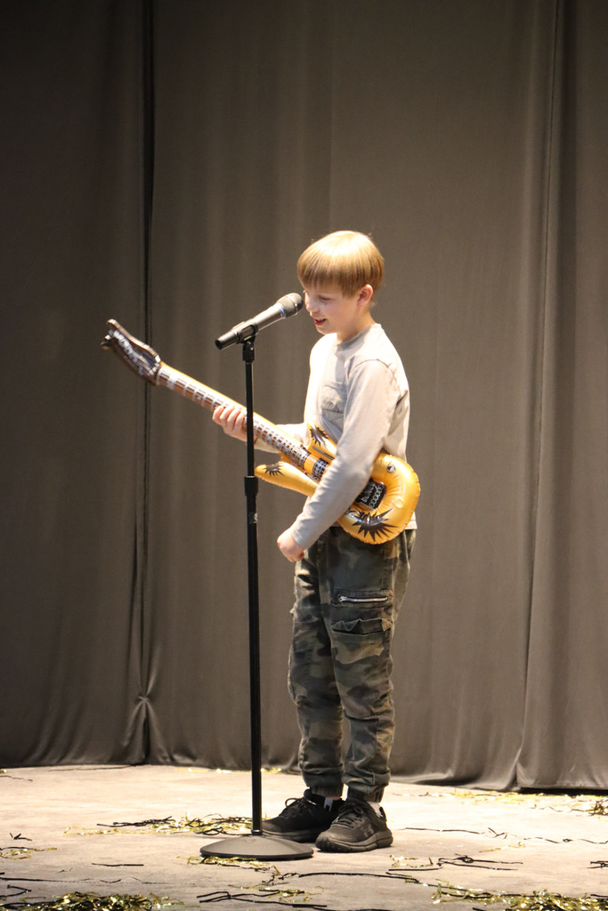 Student singing and playing air guitar. 