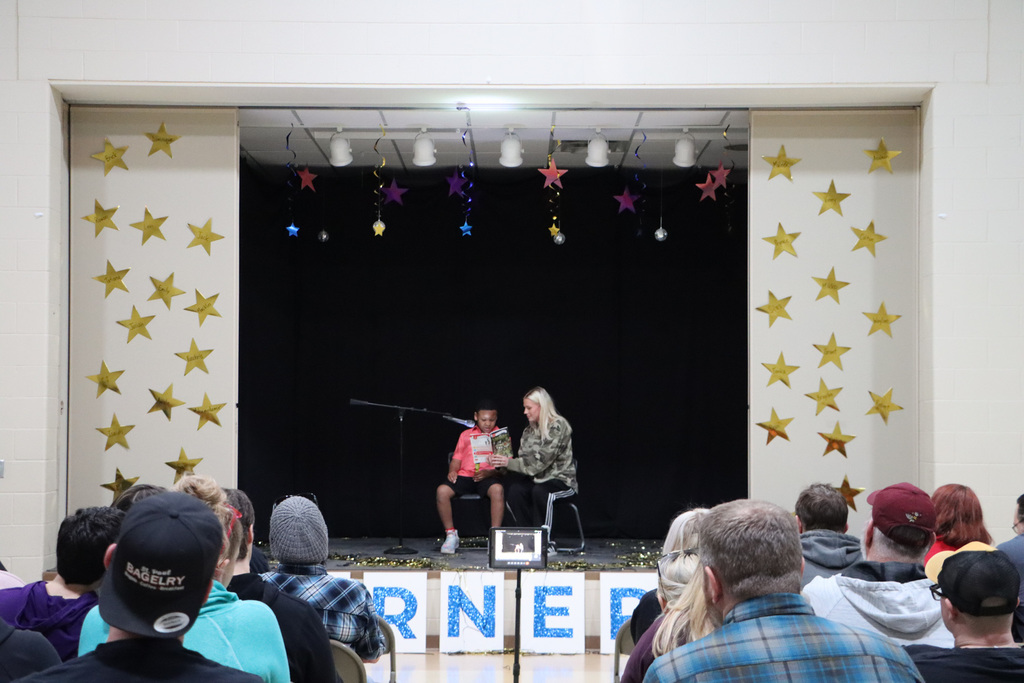 Student and staff telling a ghost story to audience. 