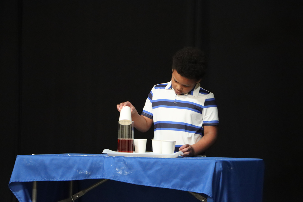 Student demonstrating a science experiment. 
